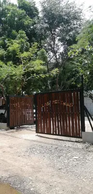 a wooden gate with writing on it in front of trees at EcoVillas Las Melinas in Playa Avellana