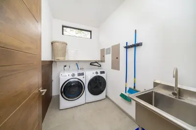 a laundry room with a washing machine and a sink at Villa Vista Pacifico - Serene Villa, Ocean View Pool, Rooftop Deck, 5 BR in Potrero