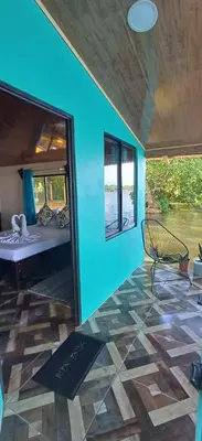 a room with a blue wall with a mirror and a chair at The Secret Eco Lodge in Tortuguero