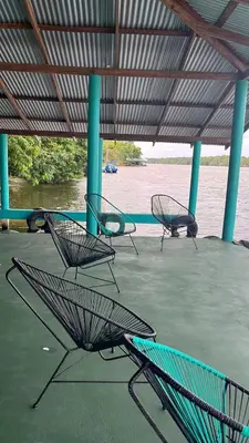 a group of chairs sitting under a roof at The Secret Eco Lodge in Tortuguero