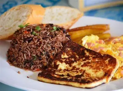 a white plate of food with toast and scrambled eggs at The Secret Eco Lodge in Tortuguero
