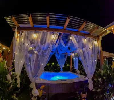 a hot tub in a gazebo at night at Arenal Tiny Houses - STAR in Fortuna