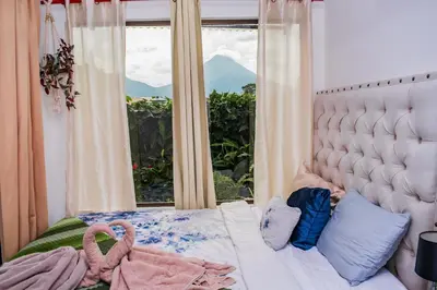 a bedroom with a bed with a large window at Arenal Tiny Houses - STAR in Fortuna