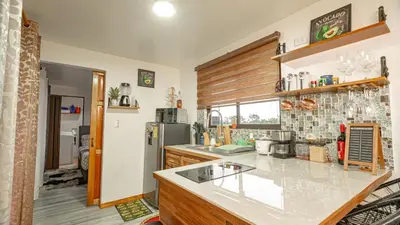 a kitchen with a counter and a refrigerator at Arenal Tiny Houses - STAR in Fortuna