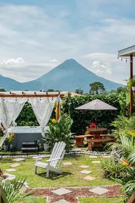 a patio with a table and chairs and a mountain at Arenal Tiny Houses - STAR in Fortuna