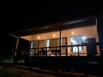 a house lit up at night with a window at Eden Corcovado in San Pedrillo