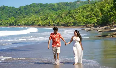a man and a woman walking on the beach at Eden Corcovado in San Pedrillo
