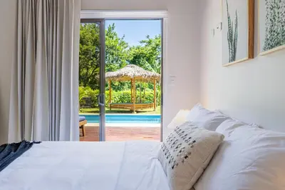 a bedroom with a bed and a view of a pool at Casa Callie- 3 Bedroom House With Pool in Tamarindo