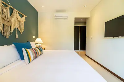 a bedroom with a large bed and a flat screen tv at Casa Callie- 3 Bedroom House With Pool in Tamarindo