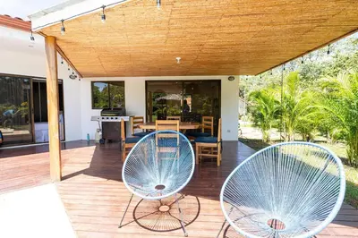 two blue chairs sitting on a deck with a table at Casa Callie- 3 Bedroom House With Pool in Tamarindo