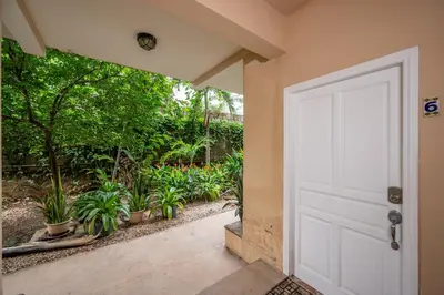 a door leading to a garden with potted plants at Tamarindo Gem: 1BR Apt in Heart! in Tamarindo