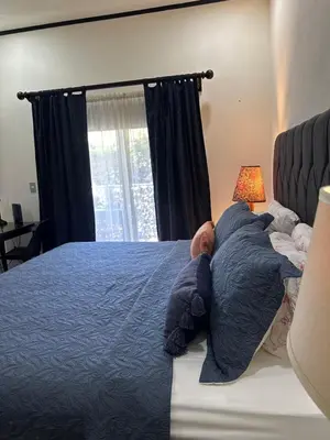 a bedroom with a bed with a baby laying on it at Tamarindo Gem: 1BR Apt in Heart! in Tamarindo