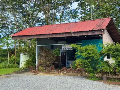 a small building with a red roof at Eco Hotel Villas del Tortuguero in Cariari