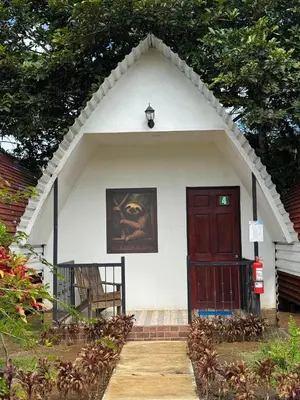 a small white house with a red door at Eco Hotel Villas del Tortuguero in Cariari