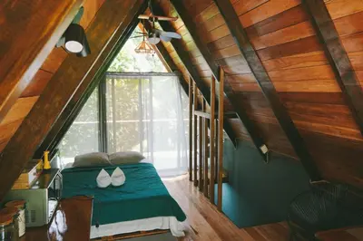 a bedroom with a bed with a green comforter and a window at Toku in Fortuna
