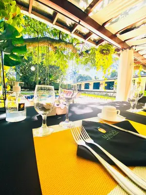 a table with two wine glasses and napkins on it at Hotel Mango Airport in Alajuela City