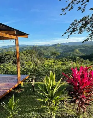 a wooden bench sitting on top of a lush green field at Luxury Villa Caoba- Private, Serene, Amazing Views at Finca Chilanga in San Mateo
