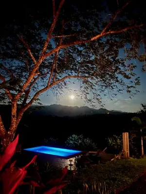 a blue picnic table under a tree at night at Luxury Villa Caoba- Private, Serene, Amazing Views at Finca Chilanga in San Mateo
