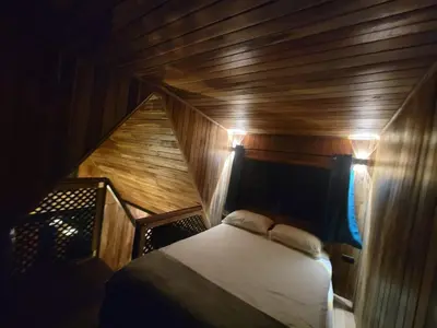 a room with a bed in a wooden boat at Myra Chalets in Bijagua