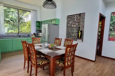 a kitchen with a table with chairs and a refrigerator at Villas Töcu-Casa Perezoso in Fortuna