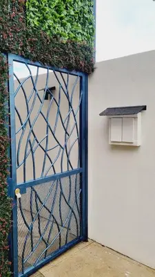a blue gate in a building with a window at Villas Flakis, Luna in Monteverde Costa Rica