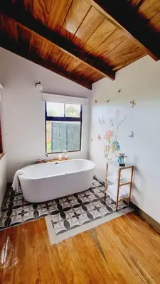 a large white tub in a bathroom with a window at Villas Flakis, Luna in Monteverde Costa Rica