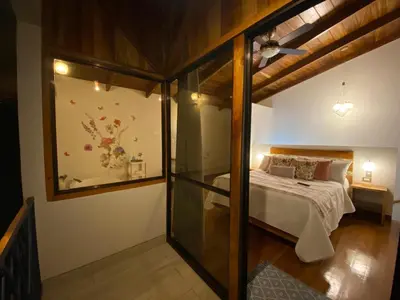 a bedroom with a bed and a glass wall at Villas Flakis, Luna in Monteverde Costa Rica