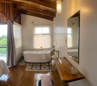a large bathroom with a tub and a large mirror at Villas Flakis, Luna in Monteverde Costa Rica