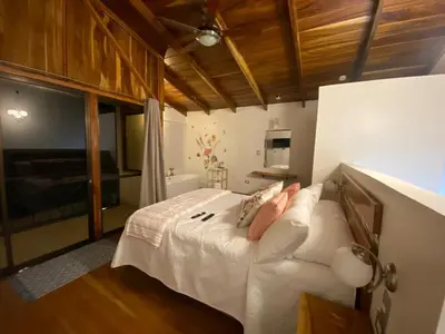 a bedroom with a bed with white sheets and pillows at Villas Flakis, Luna in Monteverde Costa Rica