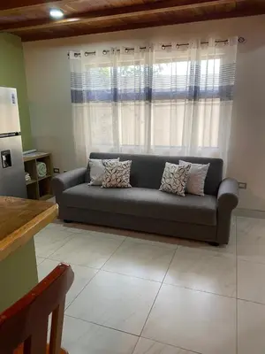a living room with a couch in front of a window at Villas Flakis, Luna in Monteverde Costa Rica