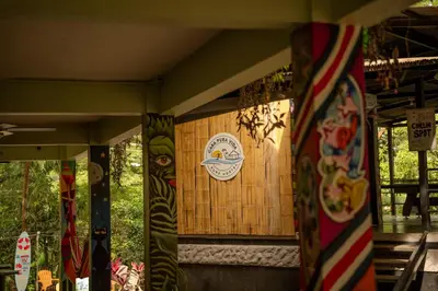 a building with a sign on the side of it at Casa Pura Vida Surf Hostel - Tamarindo Costa Rica in Tamarindo
