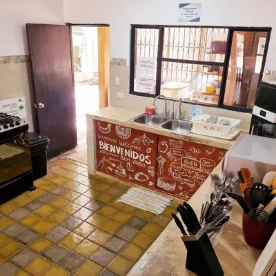 a kitchen with a counter with a sink in it at Casa Pura Vida Surf Hostel - Tamarindo Costa Rica in Tamarindo