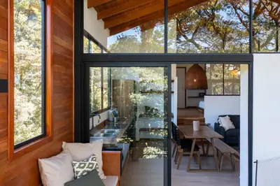 a glass house with a living room and dining room at Casas Jaguar in Monteverde Costa Rica