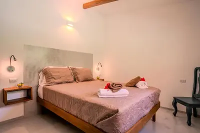 a bedroom with a bed with two towels on it at Feeling Trees Jungle Lodge in Cabuya