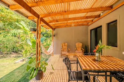 a patio with a wooden pergola and a table and chairs at Feeling Trees Jungle Lodge in Cabuya