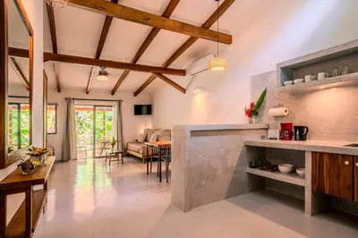 a kitchen and living room with a table and chairs at Feeling Trees Jungle Lodge in Cabuya