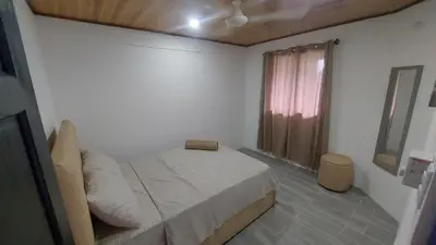 a small bedroom with a bed and a window at Casa Dñ Ana in Jacó