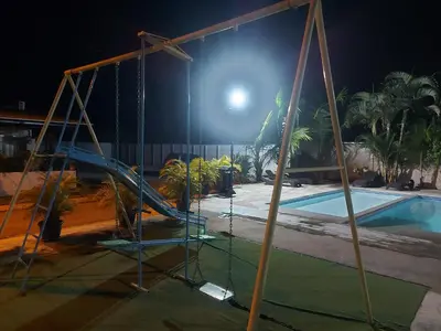 a playground with a slide next to a pool at night at Casa Dñ Ana in Jacó