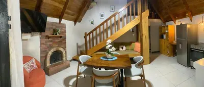 a kitchen and dining room with a table and a fireplace at Cabaña de Montaña Flaki's in Monteverde Costa Rica