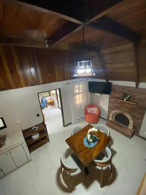 a living room with a table and a fireplace at Cabaña de Montaña Flaki's in Monteverde Costa Rica