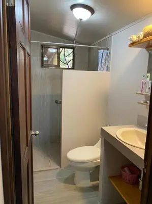 a small bathroom with a toilet and a sink at Cabaña de Montaña Flaki's in Monteverde Costa Rica