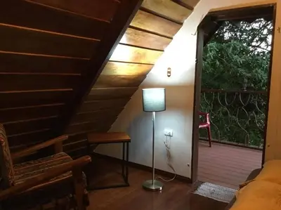 a room with a bed and a lamp on a porch at Cabaña de Montaña Flaki's in Monteverde Costa Rica
