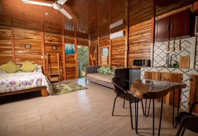 a room with a bed and a table in a room at Cabañas Los Jobos in Villarreal