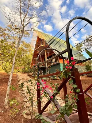 a house with a fence and flowers in front of it at Cabañas Los Jobos in Villarreal