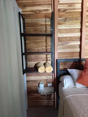 a bedroom with a wooden wall and a bed at Cabañas Los Jobos in Villarreal
