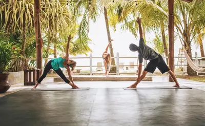 two people doing a yoga pose on a yoga mat at Encantada Ocean Cottages in Esterillos Este