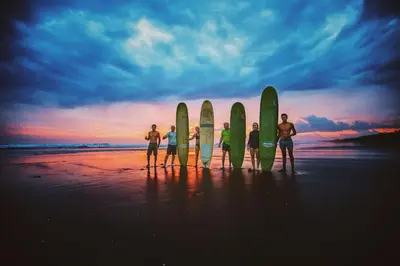 a group of people standing on the beach with their surfboards at Encantada Ocean Cottages in Esterillos Este