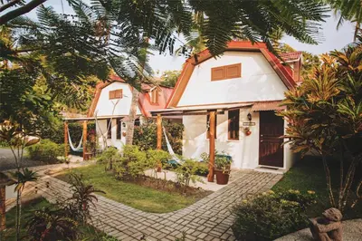 a white house with an orange roof at Encantada Ocean Cottages in Esterillos Este
