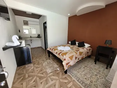 a hotel room with a bed and a television at HOTEL Y RESTAURANTE RANCHO DE SEBAS in Nicoya