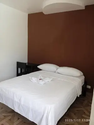 a bedroom with a bed with a white robe on it at HOTEL Y RESTAURANTE RANCHO DE SEBAS in Nicoya